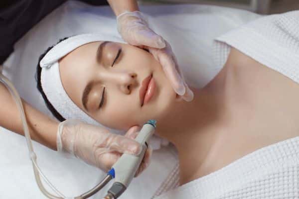 Tratamento facial não invasivo - paciente recebendo aplicação de microabrasão.