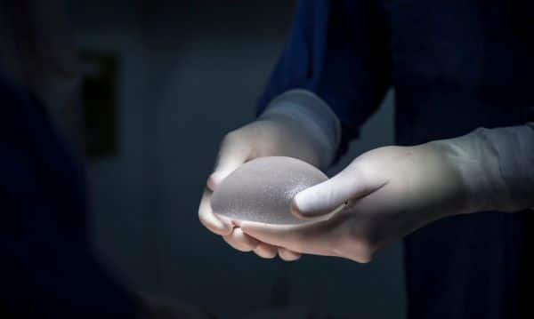 Médico mostrando prótese de silicone