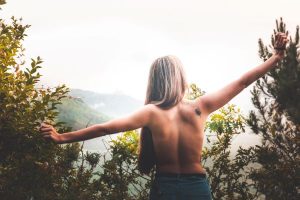 Mulher com as costas nuas em meio à paisagem