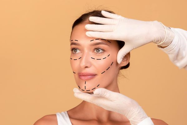 Cirurgião plástico realiza marcas para cirurgia plástica no rosto de uma mulher .