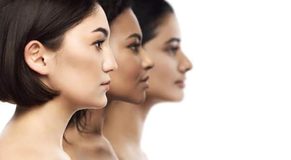 Imagem do perfil de três mulheres, oriental, negra e caucasiana, que apresentam rosto simétrico e harmônico. Objetivos que estão presentes na perfiloplastia. 