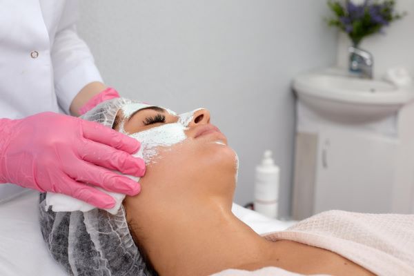 Mulher recebendo cuidados faciais por meio de um tratamento não invasivo: peeling facial.