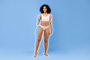 Mulher negra mostrando ótimos resultados da cirurgia plástica no corpo.