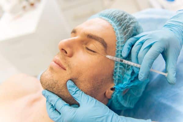 Homem recebendo tratamento de beleza para suavizar rugas com preenchedores como o ácido hialurônico.