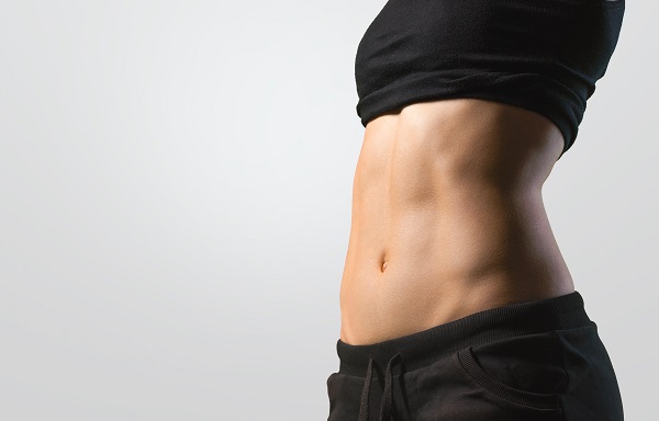 Metade de corpo feminino, com destaque para o abdômen marcado, bem definido pela lipoaspiração HD.