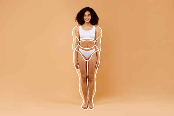 Linda mulher negra, que passou por cirurgia plástica conhecida como Mommy Makeover após gestação, apresenta o corpo contornado por linhas que demonstram como estava o corpo pós-gravidez.